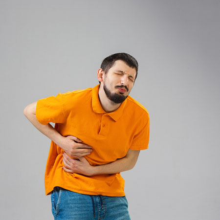 мужчина держится за бок в области печени